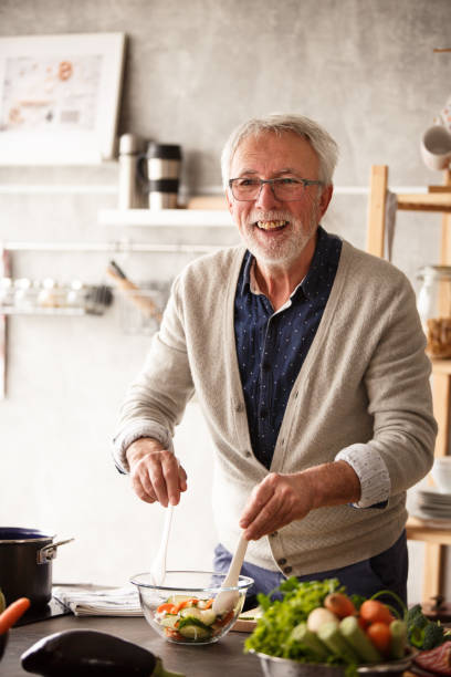 istock Cheerful senior man preparing delicious salad 1163827875
