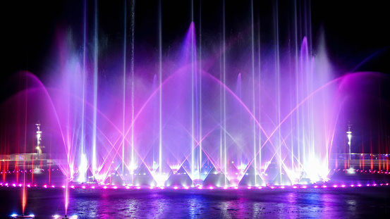 Colorful fountain dancing illuminated with music against dark night