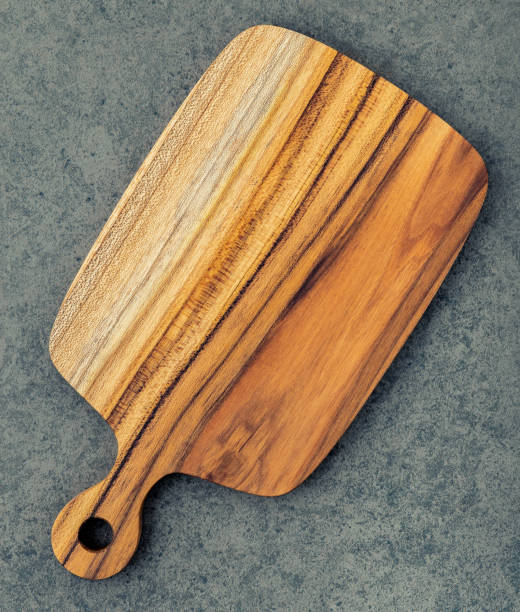 istock Chopping teak wood cutting board on dark stone background. 1163838011