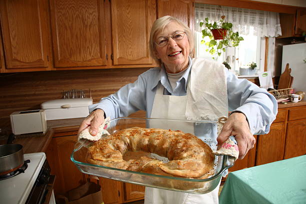 Senior woman holding fresh baked strudel stock photo