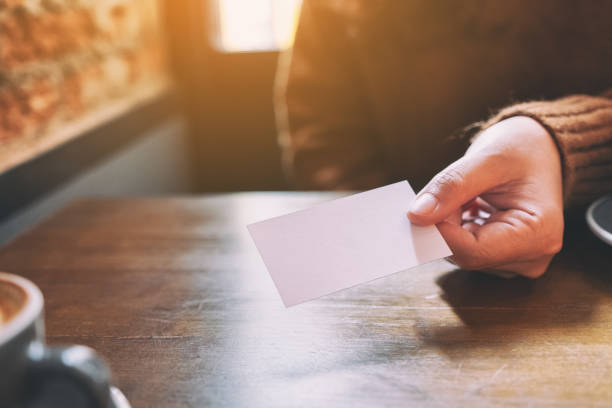 istock A woman holding and giving a blank empty business card 1163841464