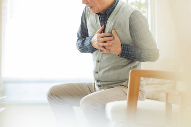 Senior man holding chest with hands stock photo