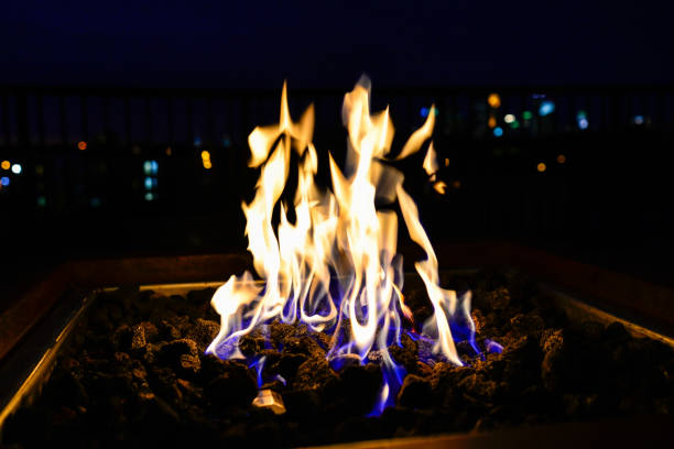 płomienie w gas fire pit na dachu z city bokeh - fire pit fire fireplace outdoors zdjęcia i obrazy z banku zdjęć