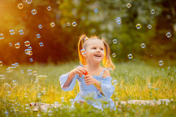 istock Little girl blows soap bubbles 1163847447
