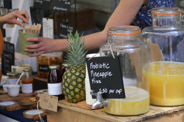 Image of probiotic pineapple fizz drink recipe in glass jar drinks dispenser with tap, at open-air street food market stall pineapples and good bacteria for stomach gut health benefits immune system, instead of active cultures probiotics yoghurt drink Stock photo of probiotic pineapple fizz drink recipe in glass jar drinks dispenser with tap, at open-air street food market stall pineapples and good bacteria for stomach gut health benefits immune system, instead of active cultures probiotics yoghurt drink liquid probiotics stock pictures, royalty-free photos & images