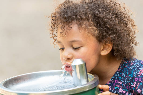 istock little girl drinking water at the schoolyard 1163850549