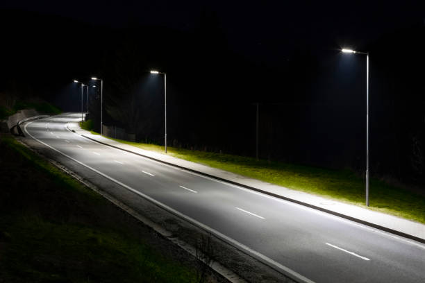 istock modern streetlights with LED technology at night, empty modern road 1163852438