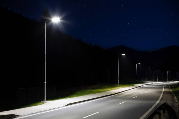 istock modern streetlights with LED technology at night, empty modern road 1163852794