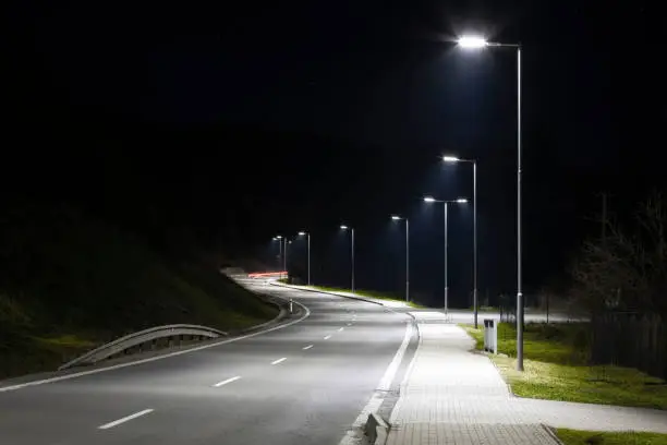 Photo of modern streetlights with LED technology at night, empty modern road
