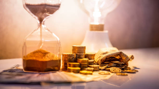 clessidra e valuta in tavola, time investment - making money gold euro symbol time foto e immagini stock