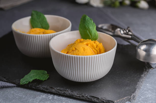 istock Mango ice cream sorbet with mint leaves 1163855274
