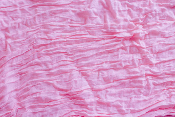 istock Soft pink colored creased fabric texture abstract background 1163855373