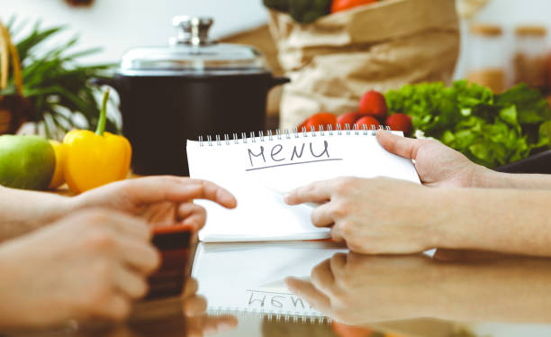istock Closeup of human hands discussing something while cooking in kitchen. Women talking about menu. Family dinner, friendship and lifestyle concept 1163862814