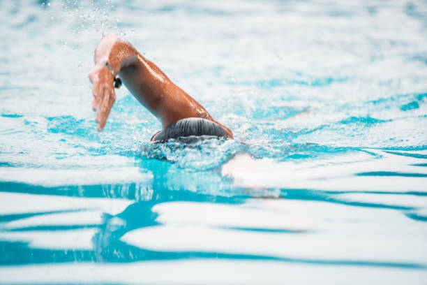 istock Athletic Young man swimming the front crawl in a pool. Swimming competition. 1163863005
