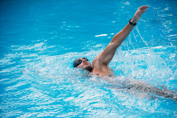 istock Athletic Young man swimming on Backstroke style. Swimming competition. 1163863878