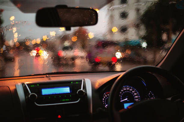istock rain droplets on car windshield, blocked traffic,Inside car with bokeh lights from traffic jam on evening time for background. 1163863882