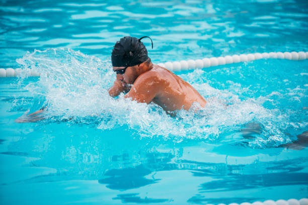 primer plano atleta masculino natación pecho en la piscina durante los campeones. - braza fotografías e imágenes de stock