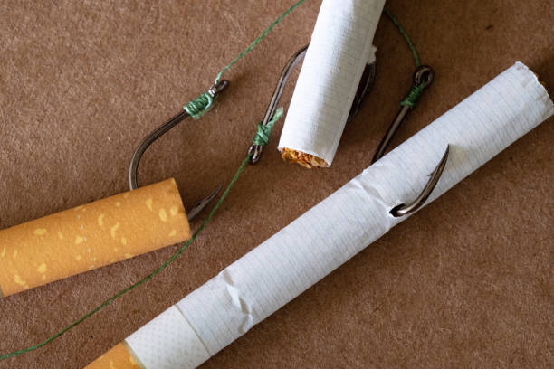 istock cigarettes and a fishing hook, brown background pressure-treated 1163866613