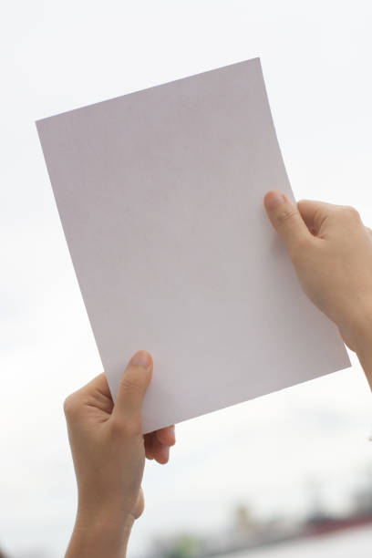 istock Woman holding paper blank 1163866636