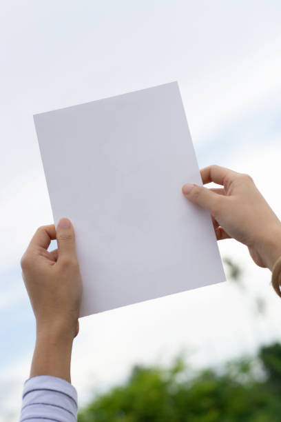 istock Woman holding paper blank 1163866637