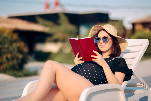 Mother to be keeping a pregnancy journal relaxing outdoors