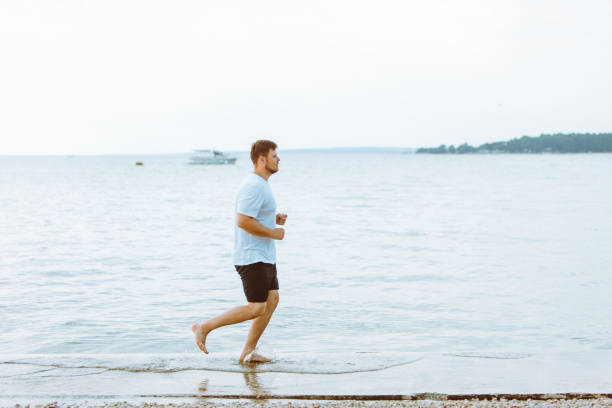 istock man running by sea beach barefoot 1163869027