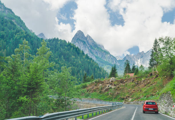 istock small red car on the road through mountains road trip 1163870859
