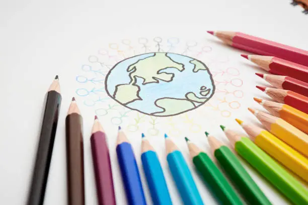 Photo of Sketch of Earth surrounded by stick figures and multicolored crayons