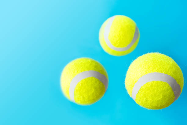 istock Yellow tennis balls floating levitating in air on light blue background active lifestyle competition victory concentration concept. Creative minimalist poster with copy space 1163878949