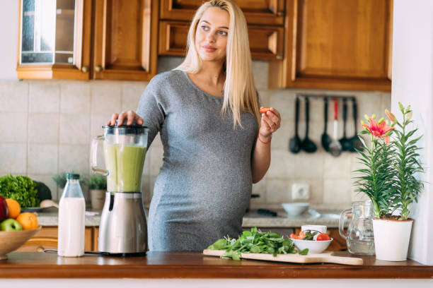 istock Pregnant woman preparing healthy eating and using blender 1163882276