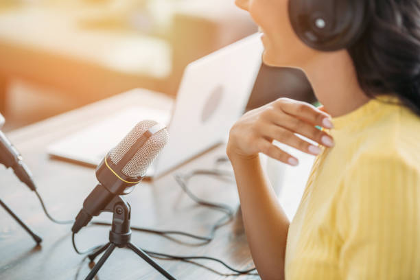 vista cortada do anfitrião de rádio de sorriso que senta-se perto do microfone no estúdio de transmissão - locutor de radio - fotografias e filmes do acervo