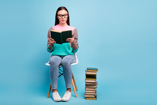 Full length body photo of focused concentrated lady in eyeglasses, specs holding thick paper book in hands isolated bright background