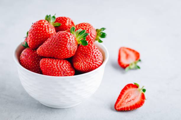 istock Fresh ripe delicious strawberry in a white bowl on a grey stone background 1163888764