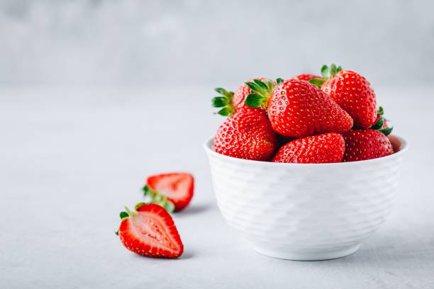 istock Fresh ripe delicious strawberry in a white bowl on a grey stone background 1163888800