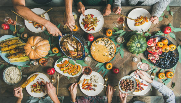 istock Friends feasting at Thanksgiving Day table with turkey and wine 1163891618