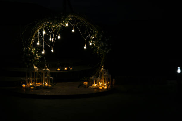 istock White flowers arch at the wedding ceremony. Outdoors decoration. Romantic rustic style. Lamps lights in the evening. 1163893155