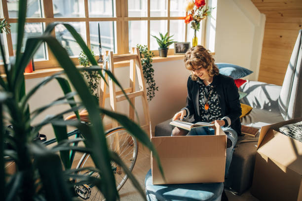 istock Woman unpacking boxes in new home 1163893316