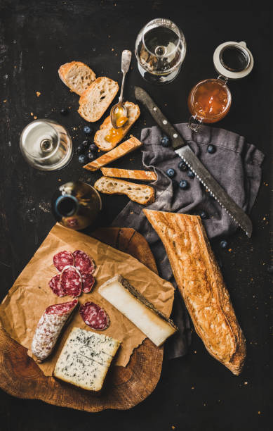 istock White wine and different snacks over black background, top view 1163893544