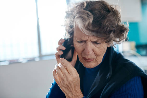 istock Unhappy senior woman using mobile phone 1163894701