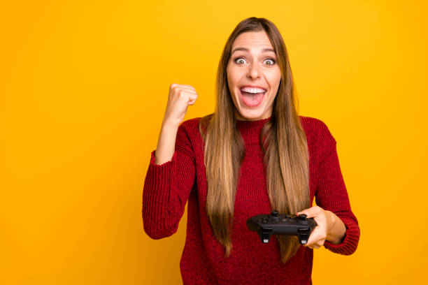 istock Pretty lady holding console hands playing online games with friends wear knitted pullover isolated yellow background 1163896319
