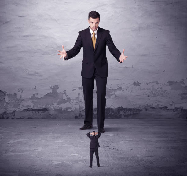 istock Angry big manager looking at small business man 1163897132