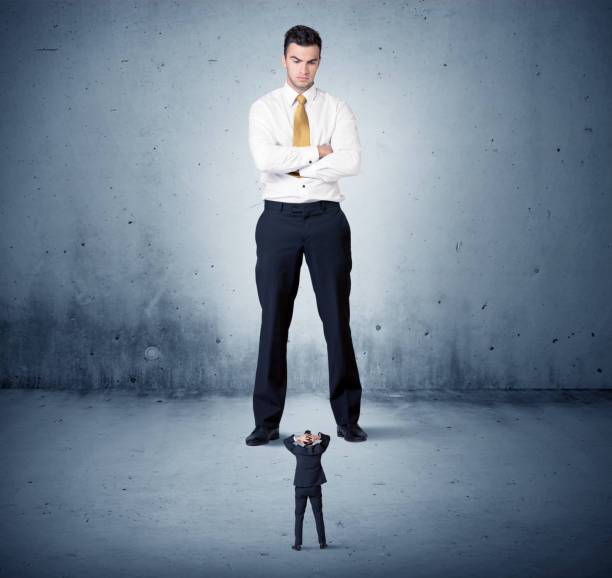 istock Angry huge business man lokking at small guy 1163897196