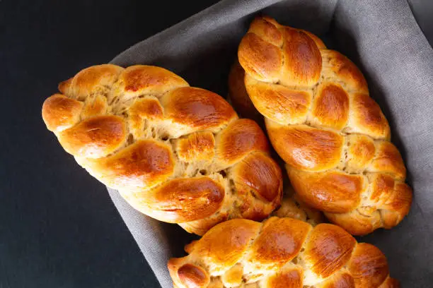 Homemade food concept fresh baked bread braid challah dough in bread basket with copy space