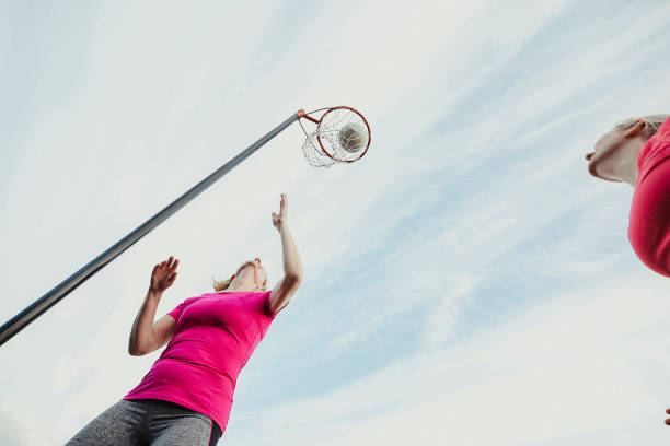 istock Woman Scoring A Netball Goal 1163901354
