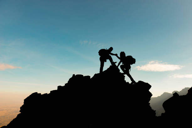 istock people with peak challenge, help and interest in mountaineering 1163901838