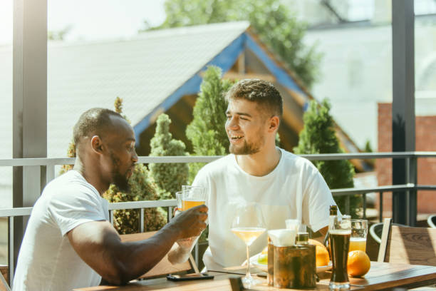 istock Young men drinking beer and celebrating together 1163902615