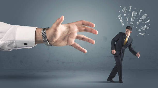 istock Business person getting away from a big hand 1163902661