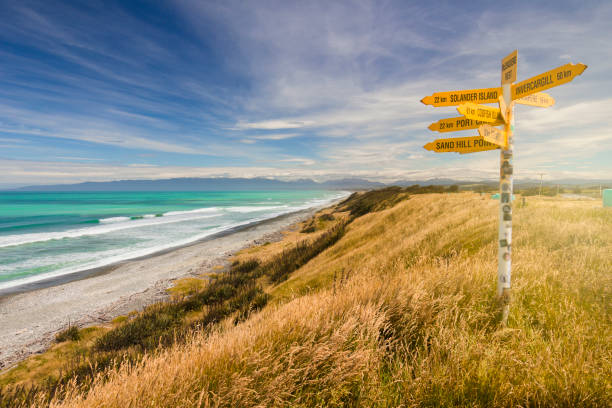 istock Distance and direction signpost on a beautiful, sunny beach. 1163903388