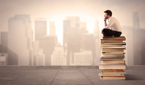 istock Man sitting on books in the city 1163903520