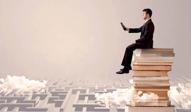 istock Man with tablet sitting on books 1163903844